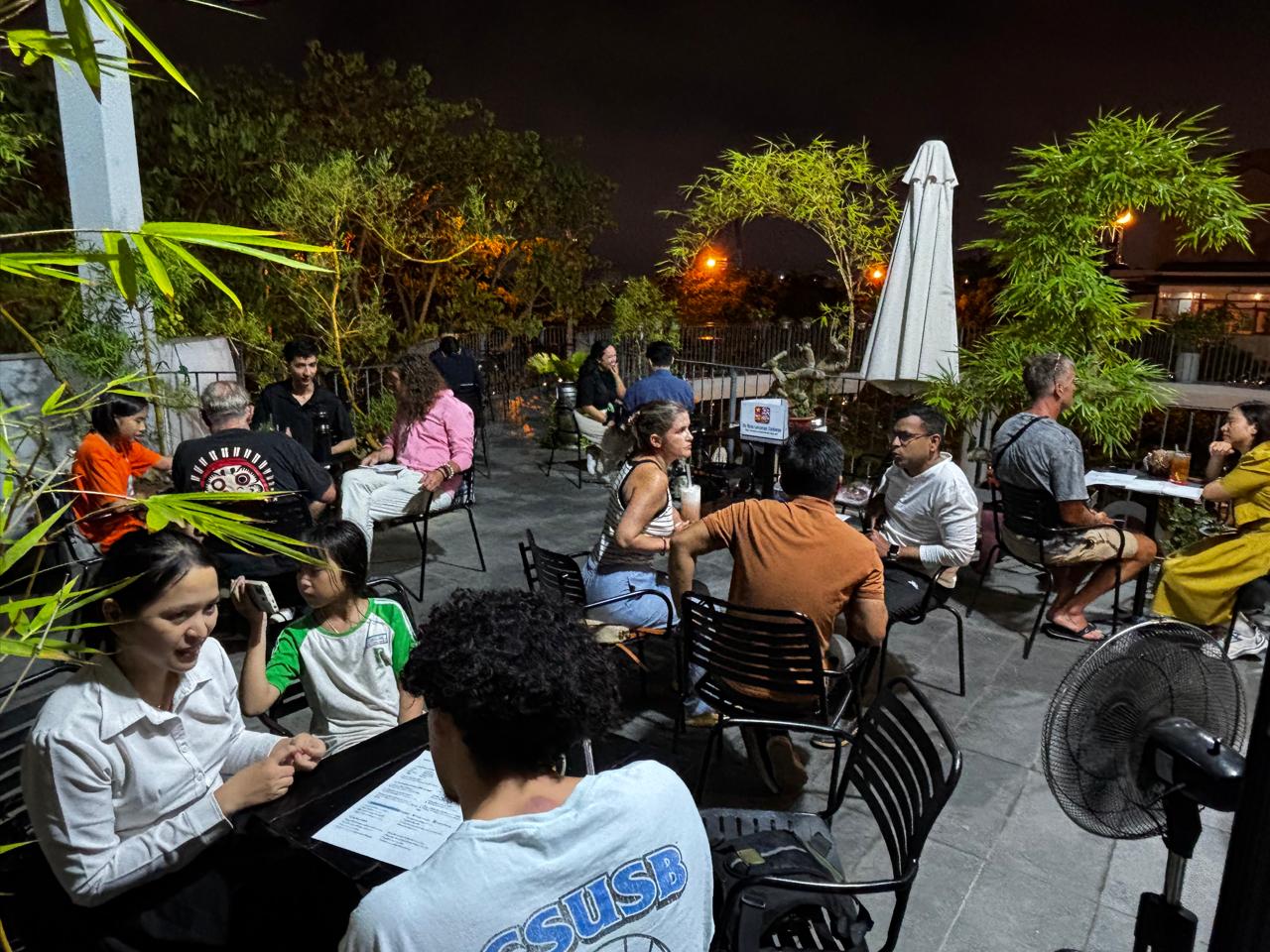 A wider evening view of the outdoor language exchange seating area on Friday, April 17, 2026.